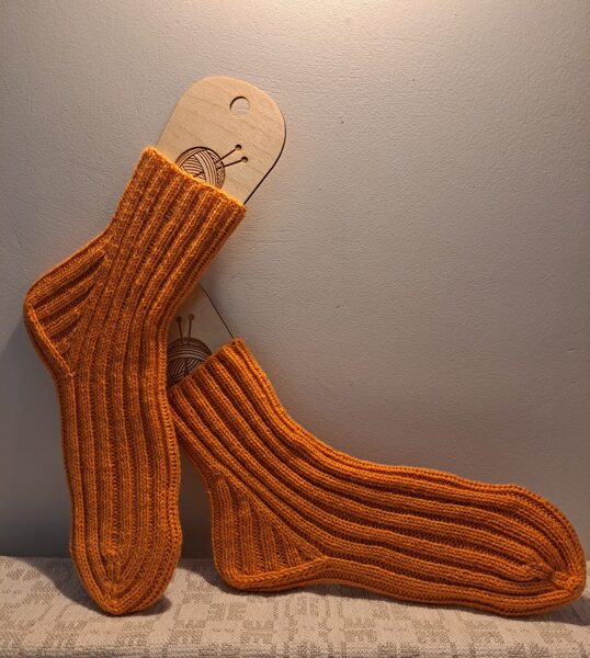 Adītas vilnas zeķes oranžā krāsā, roku darbs.